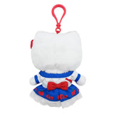 Officially licensed Hello Kitty plush keychain wearing a detailed white and blue dress with a scalloped white collar, red buttons, an apple-printed blue skirt, and a white eyelet lace hem, with a mini Hello Kitty face crossbody bag.