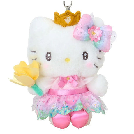 A plush keychain of Hello Kitty dressed as a princess. She wears a golden crown, a pink dress with a floral organza skirt, and a rainbow gradient bow with a pink flower. She is holding a yellow flower and has a silver metal keychain clip attached to her head.