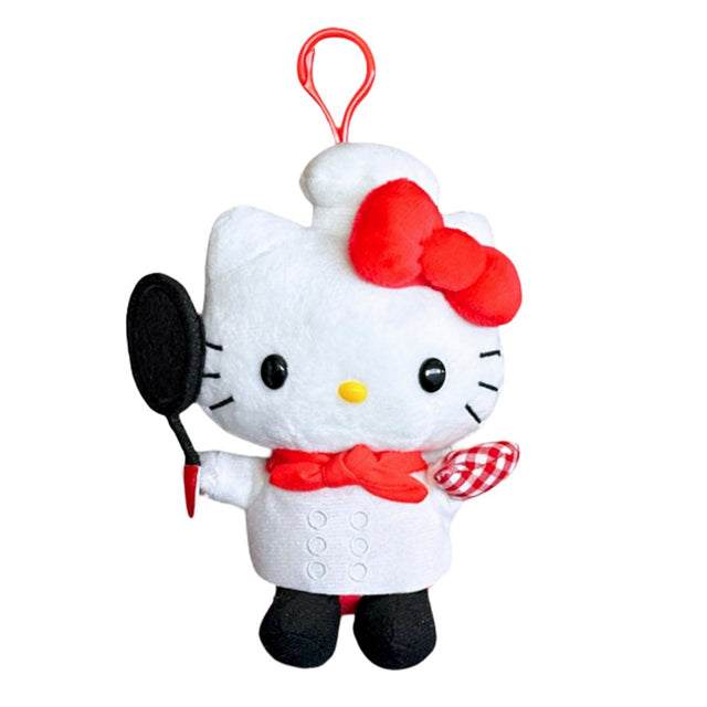 An officially licensed Hello Kitty plush keychain dressed as a chef, wearing a white chef's coat, a red necktie, and a chef's hat. She holds a black frying pan and wears a red-and-white checkered oven mitt, with a red clip attached to the top.