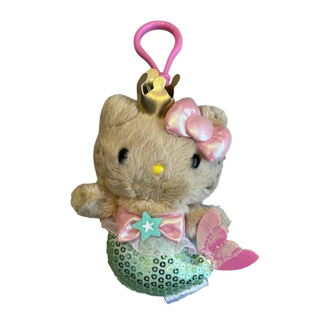 An officially licensed Sanrio Hello Kitty mermaid plush keychain clip wearing a gold crown and pink bow, featuring a green sequined tail and a pink clip.