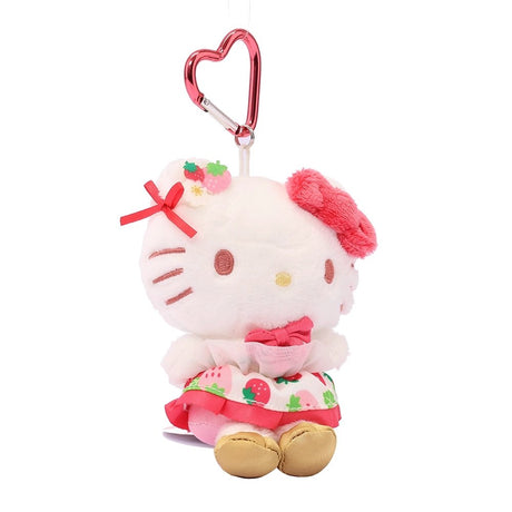 Officially licensed Sanrio Hello Kitty plush keychain from the Strawberry News 50th Anniversary Series. The plush wears a strawberry-patterned dress with pink ruffles and gold shoes, featuring a fuzzy pink bow and a metallic pink heart-shaped carabiner. Perfect displaying, bag decoration or gifting Valentine's day gift to Sanrio fans of all ages.