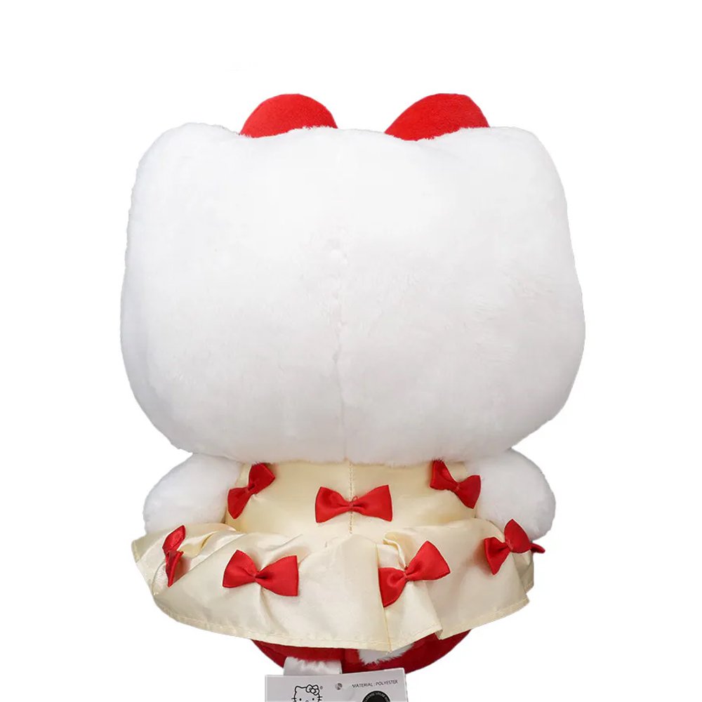 An officially licensed Hello Kitty plush doll wearing a cream-colored satin dress decorated with small red bows. She has a large red plush bow on her head and a second smaller red bow on her other ear.