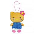An officially licensed Sanrio Hello Kitty plush keychain featuring a tan complexion, a pink hibiscus flower on her ear, and a blue denim dress. The plush has heart-shaped eyes, rhinestone facial accents, and a pink elastic loop.