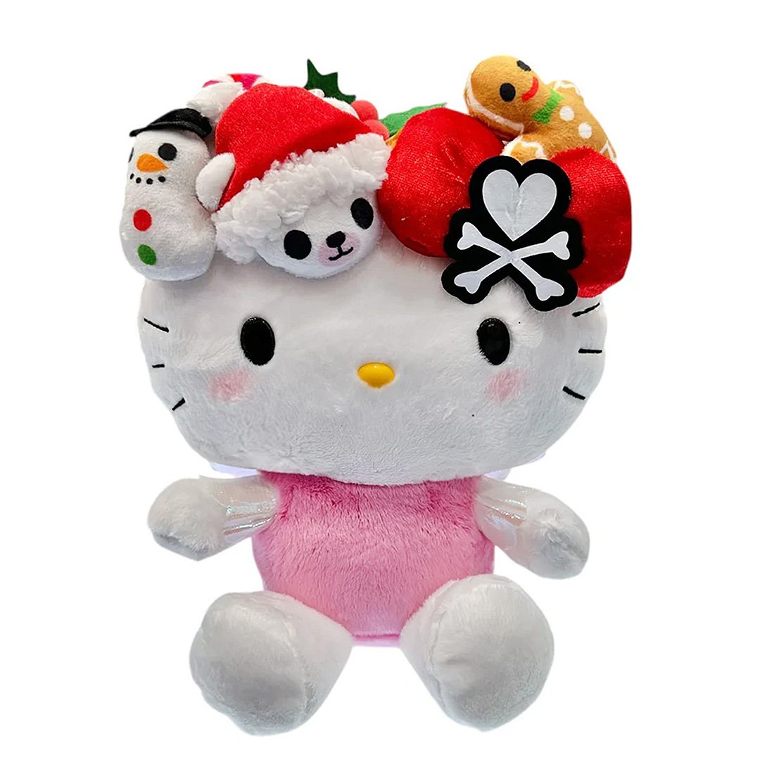 This exclusive Hello Kitty x Tokidoki collaboration is perfect for the holiday season. Her oversized head opens to reveal a collection of mini plush toys including a snowman with red and green buttons, a white polar bear in a red Santa hat, a festive gingerbread man with icing details, green holly leaves with red berries and candy cane. Hello Kitty herself features the signature Tokidoki heart and crossbones skull bow accent in her iconic red bow, along with soft pink cheeks and iridescent holographic wings