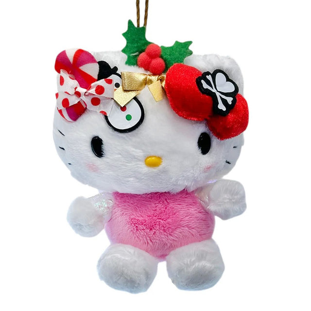 This exclusive Hello Kitty x Tokidoki collaboration is perfect for the holiday season. Her head opens to reveal a collection of mini plush toys including a snowman with red and green buttons, green holly leaves with red berries and candy cane. Hello Kitty herself features the signature Tokidoki heart and crossbones skull bow accent in her iconic red bow, along with soft pink cheeks and iridescent holographic wings on back.