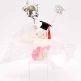 An officially licensed Class of 2026 Sanrio graduation gift set featuring six popular plush characters, Usahana, Corocorokuririn, Wish Me Mell, and Dinguri Days Mashu wearing black graduation caps. The characters are arranged like a bouquet with silver star balloons and "Congrats Grad" decorations.