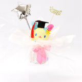 An officially licensed Class of 2026 Sanrio graduation gift set featuring six popular plush characters, Usahana, Corocorokuririn, Wish Me Mell, and Dinguri Days Mashu wearing black graduation caps. The characters are arranged like a bouquet with silver star balloons and "Congrats Grad" decorations.