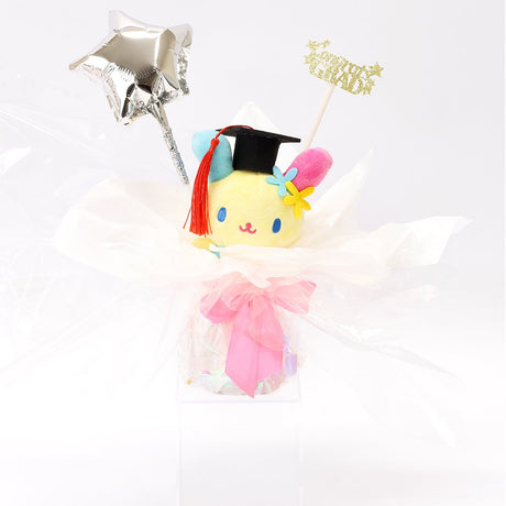 An officially licensed Class of 2026 Sanrio graduation gift set featuring six popular plush characters, Usahana, Corocorokuririn, Wish Me Mell, and Dinguri Days Mashu wearing black graduation caps. The characters are arranged like a bouquet with silver star balloons and "Congrats Grad" decorations.