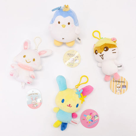 An officially licensed Class of 2026 Sanrio graduation gift set featuring six popular plush characters, Usahana, Corocorokuririn, Wish Me Mell, and Dinguri Days Mashu wearing black graduation caps. The characters are arranged like a bouquet with silver star balloons and "Congrats Grad" decorations.