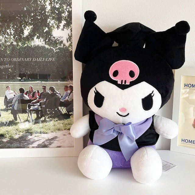 An officially licensed Sanrio Kuromi plush toy dressed in a black graduation cap with a gold tassel and a matching gown featuring a large light purple bow