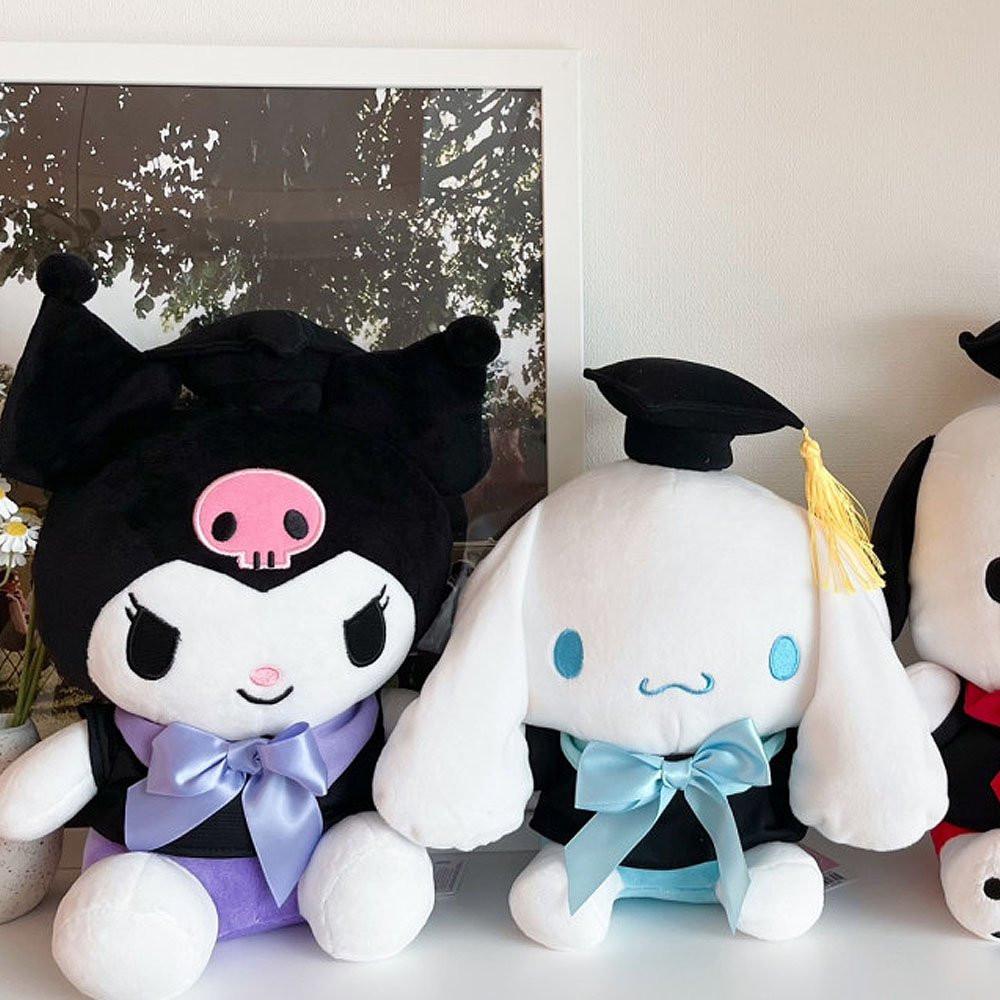 An officially licensed Sanrio Kuromi plush toy dressed in a black graduation cap with a gold tassel and a matching gown featuring a large light purple bow