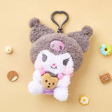 A high-texture, shaggy grey and white Kuromi plush keychain holding a small brown chocolate chip cookie. She features a classic look with pink blushed cheeks, attached to a grey heart-shaped plastic clip.