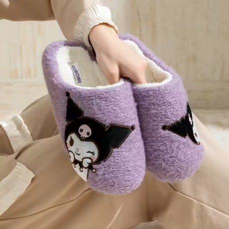 A pair of vibrant purple textured sherpa fleece Kuromi slippers with a white fleece interior, featuring a side-profile Kuromi embroidery showing her winking with her signature pink skull emblem.