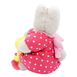 Marron Cream wearing a pink polka dot outfit with a yellow bow on a white background
