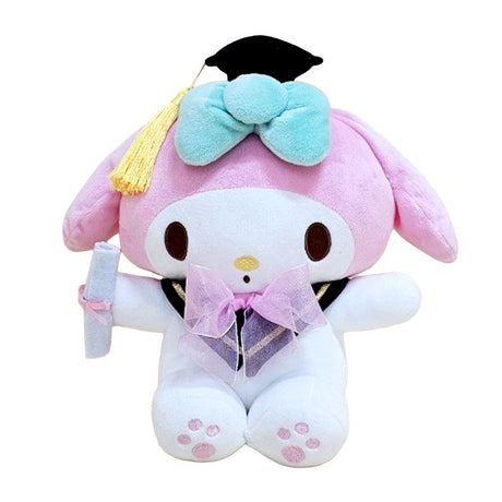 An officially licensed Sanrio 10-inch My Melody graduation plush sitting upright, wearing a black graduation cap with a yellow tassel and a pink bow around the neck while holding a white diploma
