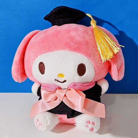 An officially licensed Sanrio My Melody plush toy dressed in a black graduation cap with a gold tassel and a matching gown featuring a large pink bow
