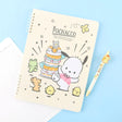 A soft yellow, officially licensed Pochacco spiral lined notebook featuring Pochacco celebrating next to a cake and the little friends.