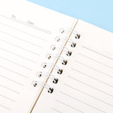 A soft yellow, officially licensed Pochacco spiral lined notebook featuring Pochacco celebrating next to a cake and the little friends.