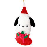 Sanrio Pochacco is dressed for the season wearing a red Santa hat with a white pom-pom while sporting his signature red bow. He sits snugly in a red Christmas stocking adorned with green holly leaves and a decorative ribbon. Crafted from soft plush material, this ornament has a cozy, huggable feel. The attached gold cord loop makes it easy to hang on your Christmas tree.