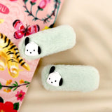A pair of pastel green faux fur hair clips featuring 3D Sanrio Pochacco character charms with black ears.
