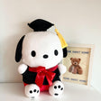 An officially licensed Sanrio Pochacco plush toy dressed in a black graduation cap with a gold tassel and a matching gown featuring a large red bow