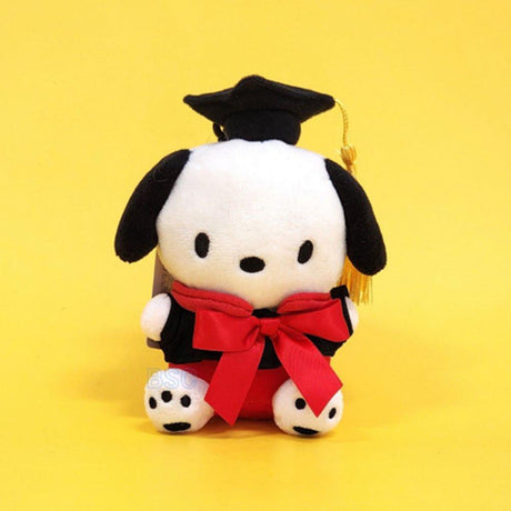 An officially licensed Sanrio Pochacco plush toy dressed in a black graduation cap with a gold tassel and a matching gown featuring a large red bow