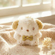 An officially licensed Sanrio Pochacco plush keychain featuring sparkling cream-colored fur, golden-tan ears, and a metallic gold bow tie
