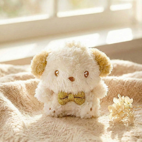 An officially licensed Sanrio Pochacco plush keychain featuring sparkling cream-colored fur, golden-tan ears, and a metallic gold bow tie
