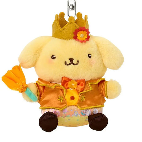A plush keychain of the Sanrio character Pompompurin, a yellow golden retriever. He wears a golden crown with a red flower on his head, a shimmering orange-gold tuxedo jacket with gold trim, and a matching orange bowtie. He holds an orange flower in his hand and features a silver metal lobster clasp.