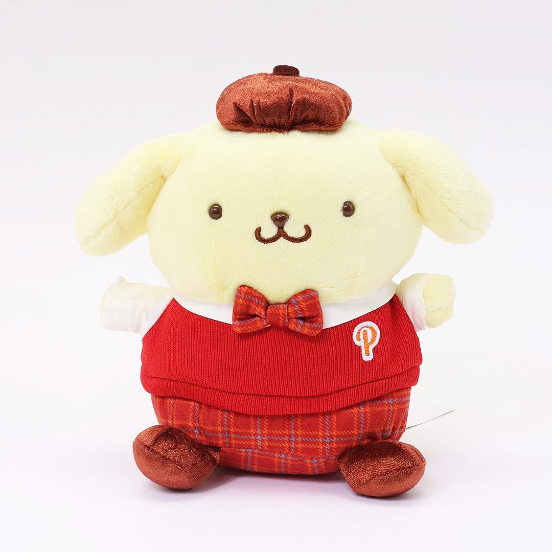 Officially licensed Sanrio Pompompurin wears a red knitted sweater vest, a plaid bow tie, matching plaid shorts, and a brown beret hat. 