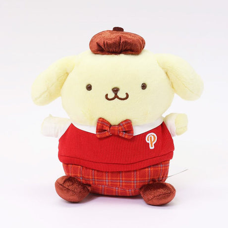 Officially licensed Sanrio Pompompurin wears a red knitted sweater vest, a plaid bow tie, matching plaid shorts, and a brown beret hat. 