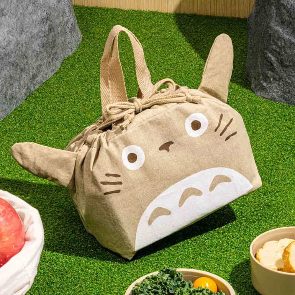 Officially licensed My Neighbor Totoro die-cut drawstring lunch pouch featuring 3D ears, Totoro's face, a drawstring tie, and top handles on natural beige fabric