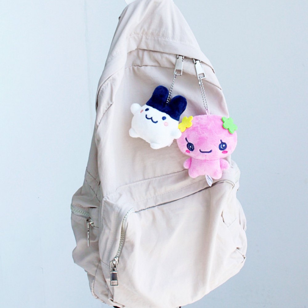 Officially licensed Tamagotchi plush keychain characters Floritchi and Mimitchi hanging on the backpack.