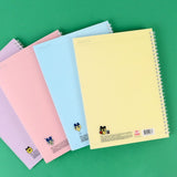 A set of four officially licensed Tamagotchi spiral notebooks in yellow, purple, blue, and pink, each featuring different character illustrations.