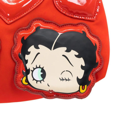 A vibrant red Betty Boop shoulder bag featuring a glossy patent red bow, heart appliqués, and iconic character graphics of Betty Boop and red lips, with a slim over-the-shoulder strap.