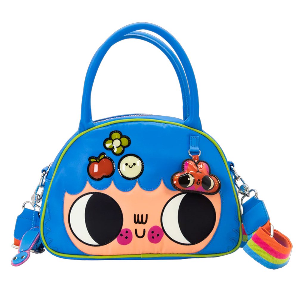 An officially licensed Whatever! blue dome-shaped handbag featuring a large character face with giant black eyes and pink cheeks. The bag is decorated with a green bat-winged patch, a star, and a lightning bolt. It includes blue top handles and a detachable rainbow-striped shoulder strap.