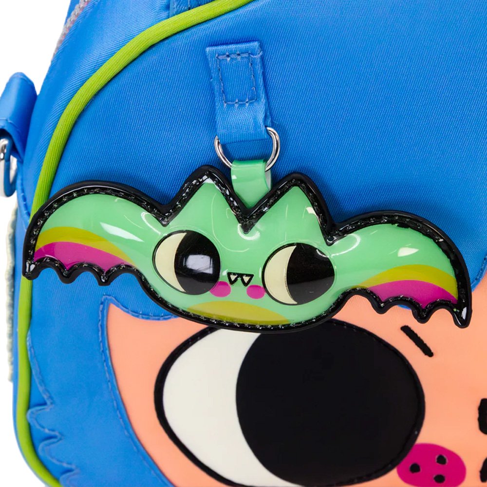 An officially licensed Whatever! blue dome-shaped handbag featuring a large character face with giant black eyes and pink cheeks. The bag is decorated with a green bat-winged patch, a star, and a lightning bolt. It includes blue top handles and a detachable rainbow-striped shoulder strap.