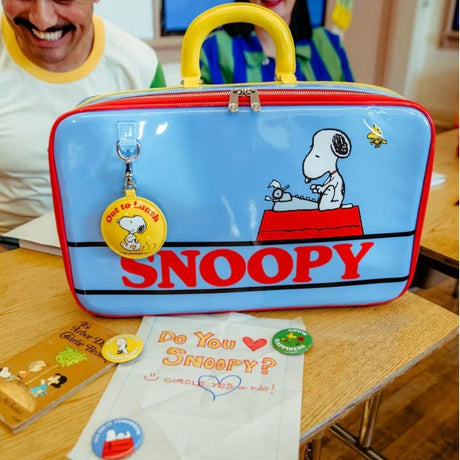 A retro-style light blue Snoopy laptop bag or briefcase featuring Snoopy and Woodstock, finished with a yellow top handle and an "Out to Lunch" small charm attached