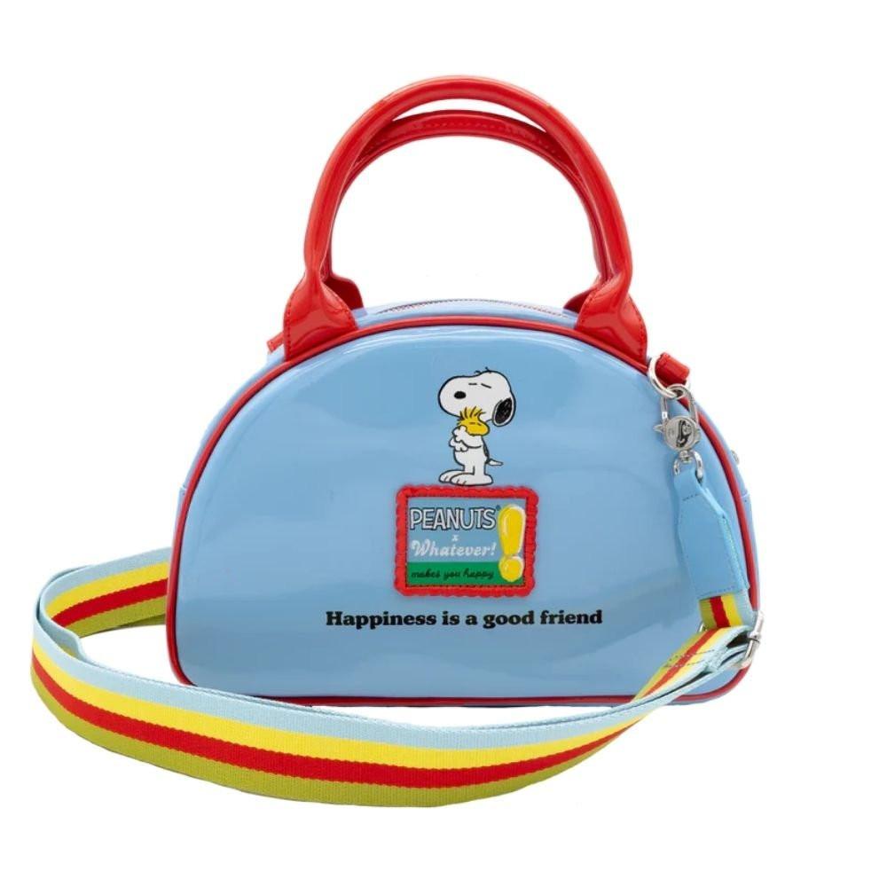 A light blue dome-shaped Snoopy crossbody bowler bag featuring Snoopy sitting on his red doghouse against a cloudy sky, with red handles, a striped rainbow shoulder strap, and a red heart-shaped Woodstock charm.