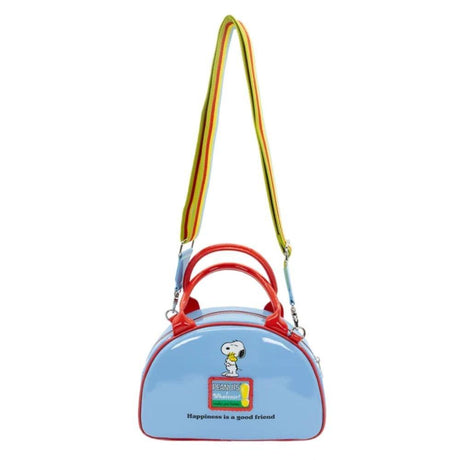 A light blue dome-shaped Snoopy crossbody bowler bag featuring Snoopy sitting on his red doghouse against a cloudy sky, with red handles, a striped rainbow shoulder strap, and a red heart-shaped Woodstock charm.