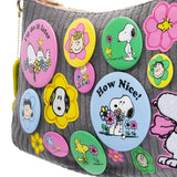 A grey corduroy shoulder bag decorated with an assortment of colorful Peanuts character buttons and floral patches