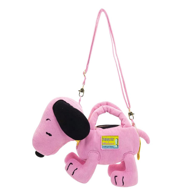 A pink corduroy plush bag shaped like Snoopy with floppy black ears, featuring a small top handle, a detachable pink shoulder strap, and a colorful yellow and blue "PEANUTS" patch on the side