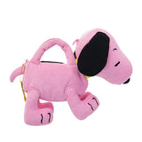 A pink corduroy plush bag shaped like Snoopy with floppy black ears, featuring a small top handle, a detachable pink shoulder strap, and a colorful yellow and blue "PEANUTS" patch on the side