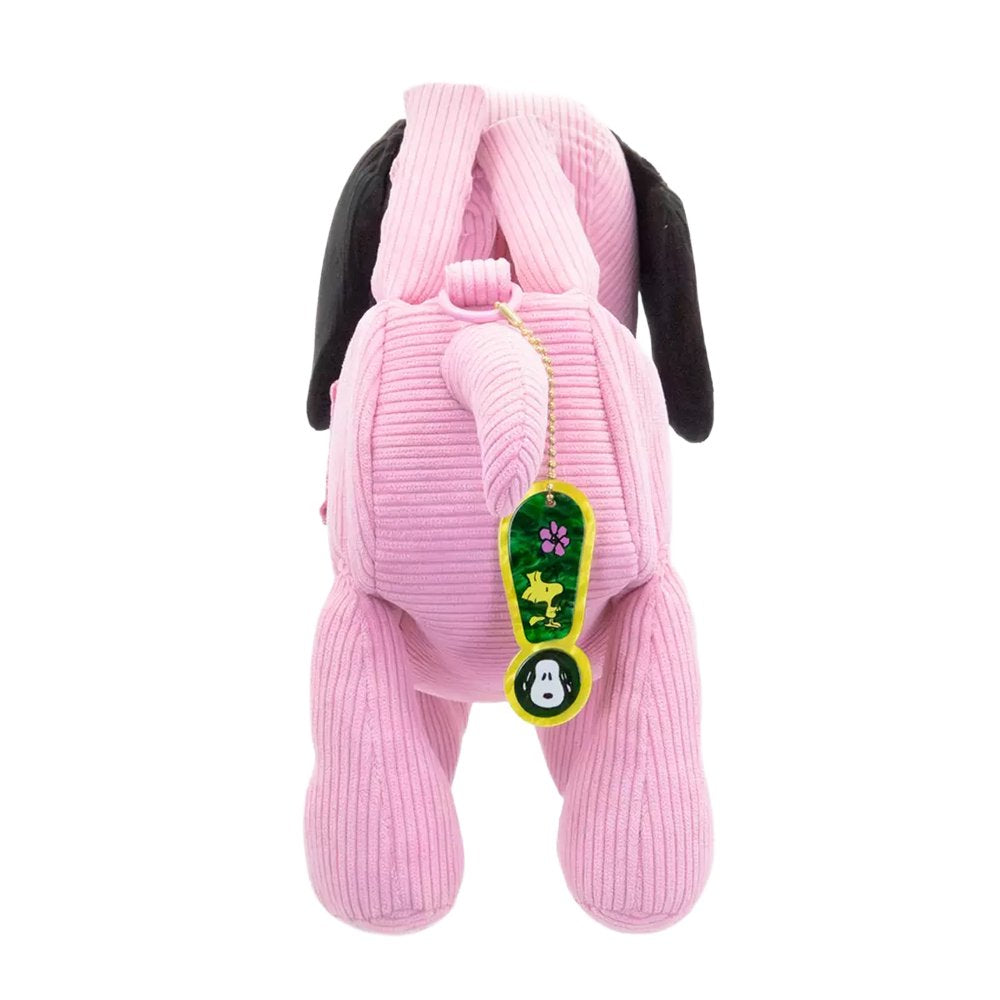 A pink corduroy plush bag shaped like Snoopy with floppy black ears, featuring a small top handle, a detachable pink shoulder strap, and a colorful yellow and blue "PEANUTS" patch on the side