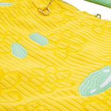 A bright yellow corduroy tote bag shaped like Snoopy's head with long, floppy green ears, subtle embroidered yellow flowers on the face, and a hanging black Peanuts keychain charm
