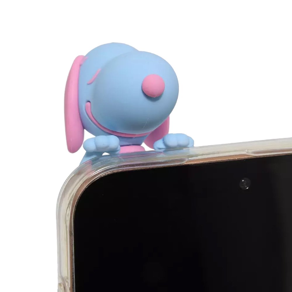 Five colorful miniature Snoopy figures in pastel sherbet colors designed to hang from edges, shown alongside a close-up of a blue and pink Snoopy figure clinging to the corner of a smartphone.
