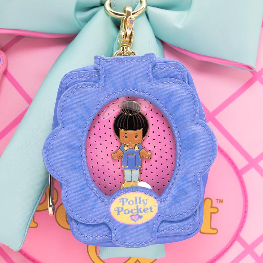 A collection of Polly Pocket mystery items including four colorful character enamel pins and four flower-shaped miniature bag charm keychains in yellow, pink, blue, and mint green.