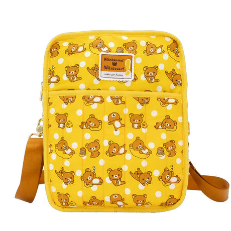 An officially licensed Rilakkuma reversible quilted crossbody bag in yellow color. The front features a repeating pattern of Rilakkuma and a front pocket.