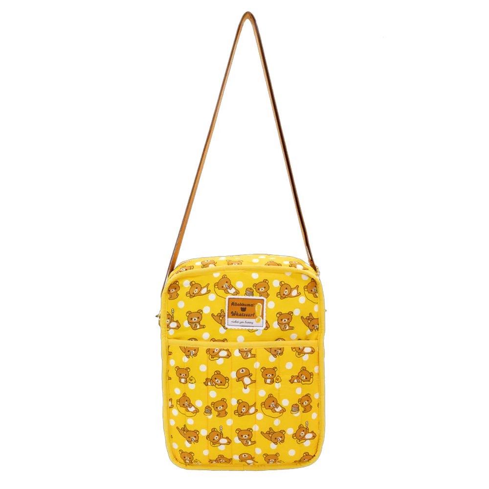 An officially licensed Rilakkuma reversible quilted crossbody bag in yellow color. The front features a repeating pattern of Rilakkuma and a front pocket.