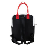 Reversible and convertible horror movie Terrifier 2 tote bag showcasing a split black-and-white design with red blood splatters, a bloody meat cleaver bag charm, and an Art the Clown charm